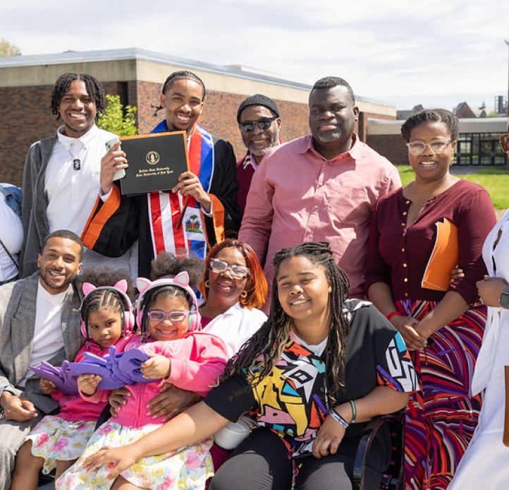 Graduate with their family celebrating their accomplishment