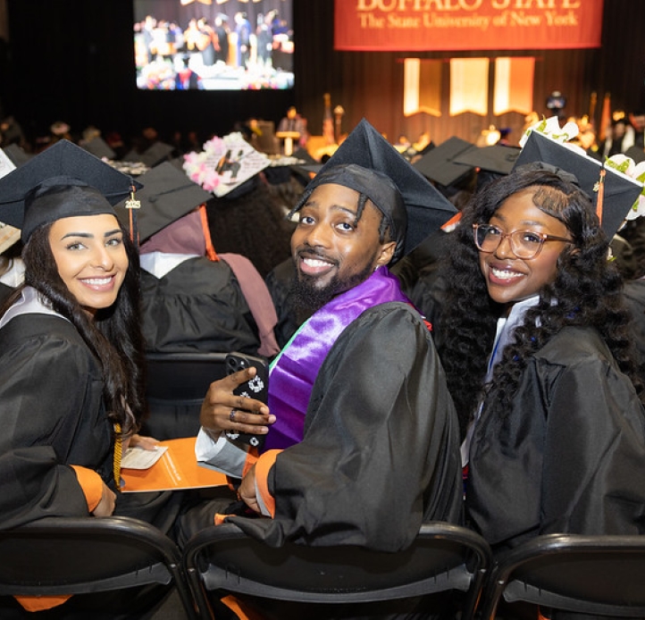 three students seated at commencement ceremony