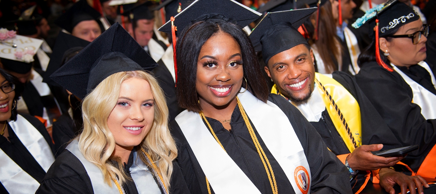 Three Commencement students smiling