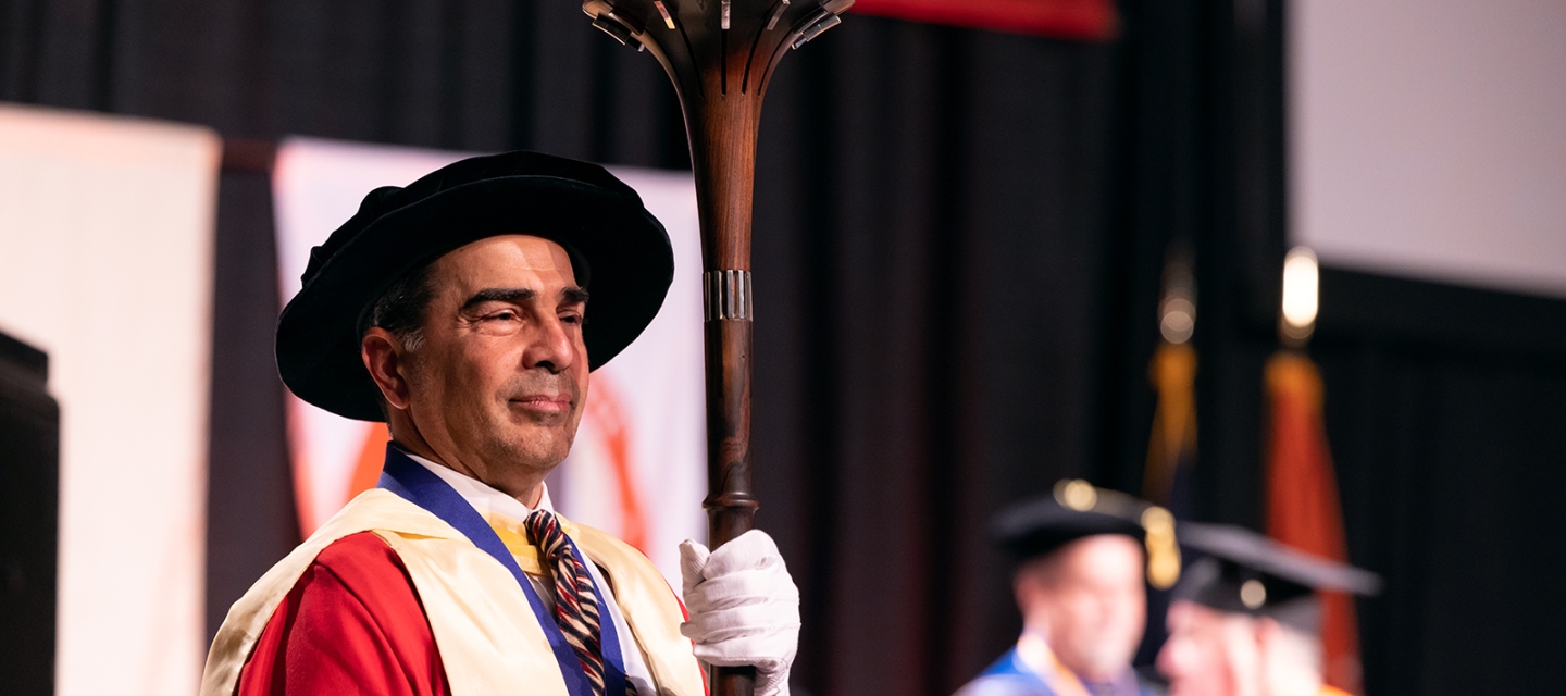 Faculty member carrying a sceptor